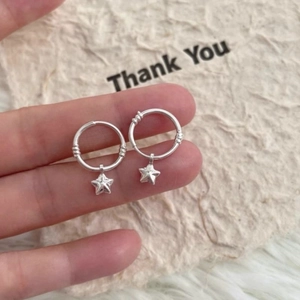 Boucles d'oreilles créoles étoile en argent S925 avec texture sphère sur carte beige