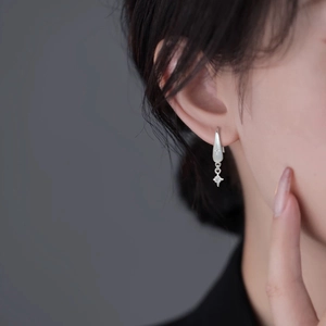 Eleganti orecchini a stella in argento con zirconi scintillanti su una modella