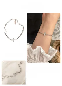 Detailed view of dual-layer S925 silver bracelet featuring a sparkling zircon cross charm