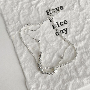 Detail shot of double-layer S925 sterling silver star beaded bracelet on white texture