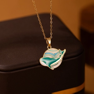 Macro view of whale and wave enamel pendant on a premium jewelry gift box