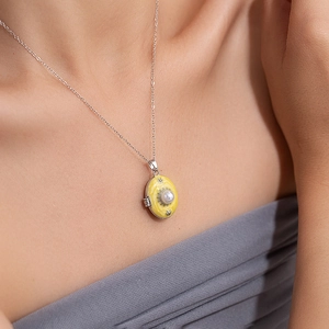 Close-up of vintage oval floral locket necklace with pearl detail on a model neck