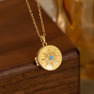Detailed close-up of golden vintage solar locket necklace on dark wood background