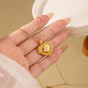 Detailed close-up of a vintage gold heart locket with bee relief and MINE engraving