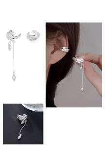 Macro detail of textured bamboo leaf earrings with silver tassels and white pearls
