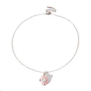 Macro view of a gold flower necklace with a pink oval pendant and a white pearl accent