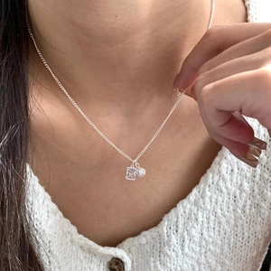 Silver necklace featuring square zircon and pearl pendant on a delicate chain model neck