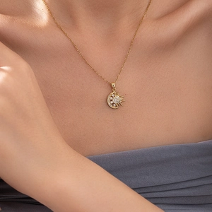 Élégant collier soleil et lune doré pour femme avec des pendentifs sertis de cristaux