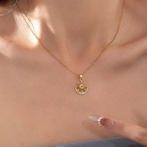 Élégant collier doré avec pendentif soleil et lune et pierre gemme bleue