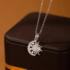 Vue macro d'un pendentif soleil et lune en argent avec serti micro-pave de zircons brillants