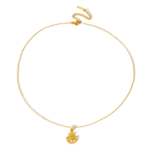 Gros plan du pendentif soleil et lune avec gemme verte et cristaux sur chaîne dorée