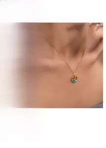 Detail of fishtail necklace featuring blue zircon star moon pendant in gold and silver
