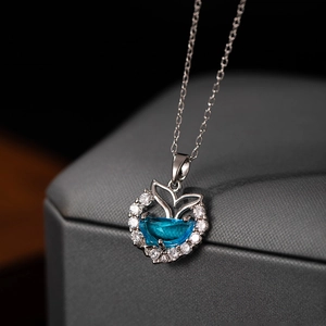 Macro shot of silver mermaid tail necklace with blue zircon and sparkling white crystals