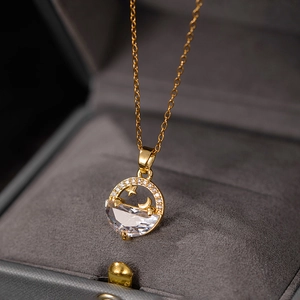 Macro detail of gold-plated moon and star pendant with large zircon in a jewelry box