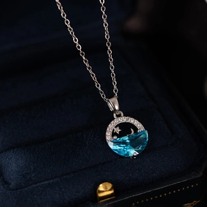 Macro shot of zircon fishtail star and moon pendant necklace in a velvet jewelry box