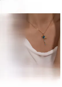 Detail of star fish tail pendant with blue zircon tassel on a gold and silver chain