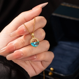 Golden mermaid tail necklace with blue gemstone and sparkling cubic zirconia stars