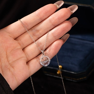 Detail of silver fishtail necklace with moon star pendant and zircon in a jewelry box