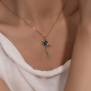 Elegant gold necklace with blue star pendant and crystals shown on a model