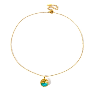 Macro detail of mermaid tail pendant with blue zircon on a golden chain necklace