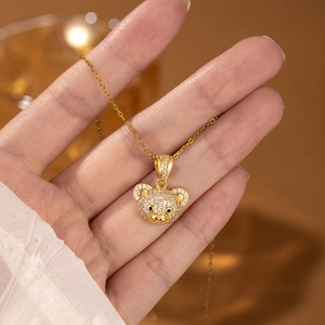 Detailed close-up of a bear pendant necklace with sparkling zircons held in hand