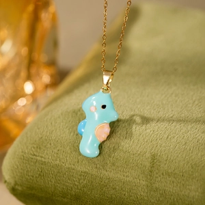 Vue macro d'un pendentif hippocampe en émail bleu clair avec chaîne dorée sur velours