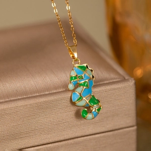 Détail du pendentif hippocampe avec émail coloré sur une chaîne dorée élégante