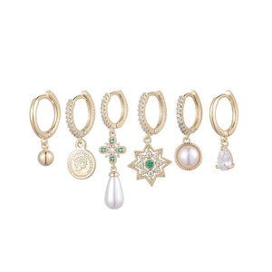 Détail d'un ensemble de six boucles d'oreilles dorées avec perles et cristaux verts