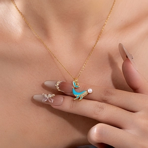 Collier dauphin doré avec émail bleu et perle sur une chaîne délicate en acier titane