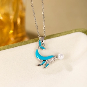 Détail du pendentif baleine avec émail bleu, cristaux sertis et une perle blanche