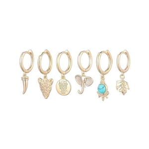 Détail de boucles d'oreilles dorées vintage avec breloques d'animaux et perle turquoise
