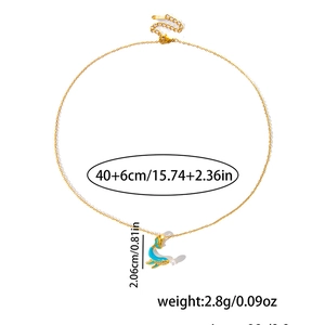Vue détaillée d'un collier dauphin doré en émail bleu avec mesures de taille