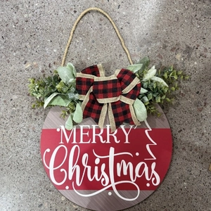 Round wooden Christmas sign with Merry Christmas text, plaid bow and pine accents