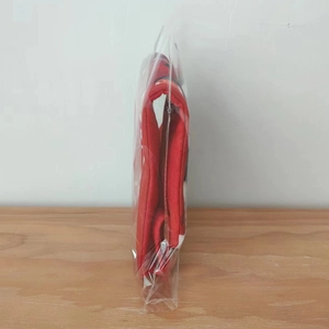 Detailed view of red Christmas stocking packaged in a clear bag on wooden surface