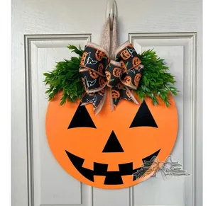 Close-up of Halloween pumpkin door sign with festive bow and green leaves on white door