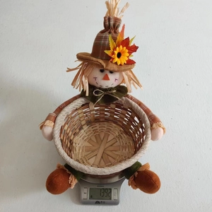 Close-up of scarecrow candy basket weighing 139.2g on a scale for Thanksgiving decoration