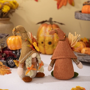 Gros plan de deux gnomes d'automne avec feuilles d'érable et tournesols sur chapeaux