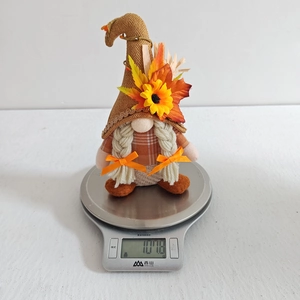 Détail d'un gnome d'automne avec tournesol et feuille d'érable sur une balance de cuisine