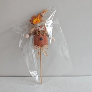 Dettaglio decorazione spaventapasseri del raccolto con cappello di paglia e fiori autunno