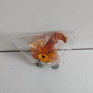 Détail d'un gnome d'automne sous emballage avec décor de tournesol et de feuille d'érable