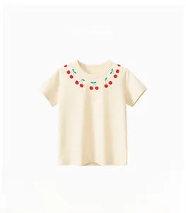 Détail d'un t-shirt beige en coton pour enfant avec un joli col à imprimé cerise