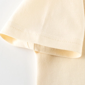 Détail de la manche d'un t-shirt en maille de coton crème avec finition à double couture
