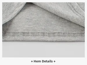 Macro view of grey cotton T-shirt hem showing precise double-needle stitching details