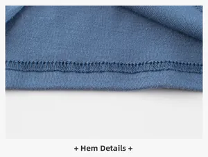 Detailed macro view of the double-stitched hem on this blue knit cotton kid's t-shirt