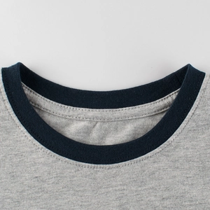 Close-up of kids' gray knit t-shirt featuring a contrast navy blue ribbed crew neck collar