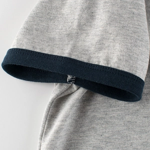 Close-up of kids' heather grey T-shirt featuring navy blue ribbed cuff and knit texture