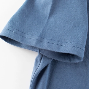 Detailed close-up of grey-blue cotton t-shirt sleeve with double-needle stitching