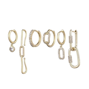 Détail de boucles d'oreilles dorées avec perles, étoiles et zircons scintillants