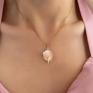 Detail einer eleganten Goldkette mit rosa Tulpenanhänger am Hals eines Models