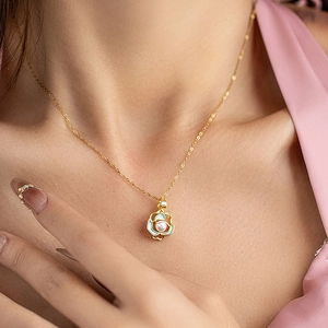Elegante goldene Lotuskette mit hellblauem Emaille- und Perlenanhänger am Frauenmodel
